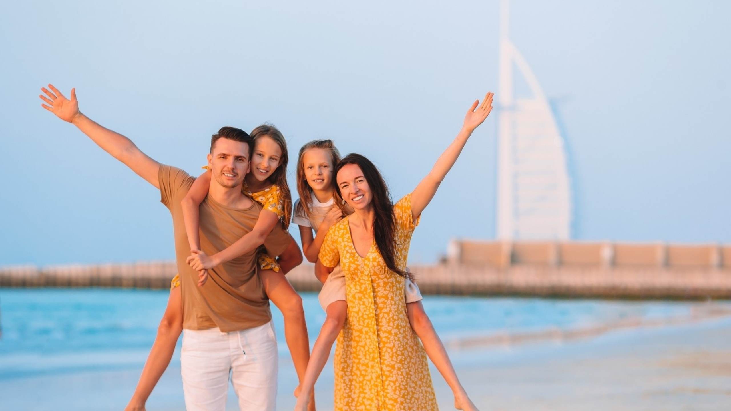 Family with children on beach with Burj Al Arab Dubai confident kids resilient parenting emotional mindful
