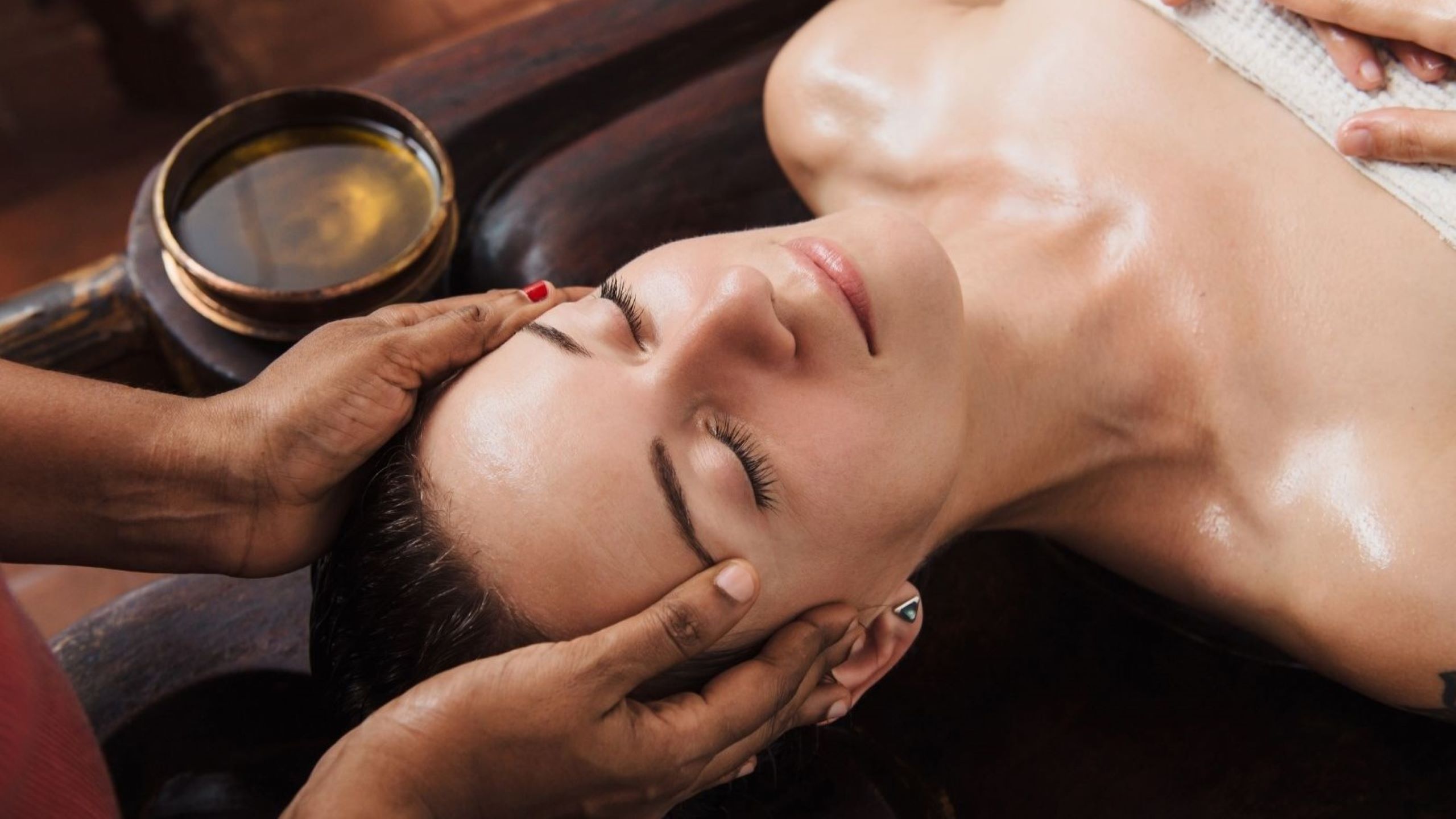 Woman receiving Ayurvedic facial with herbal oils at luxury spa Ayurvedic beauty rituals holistic radiant glow