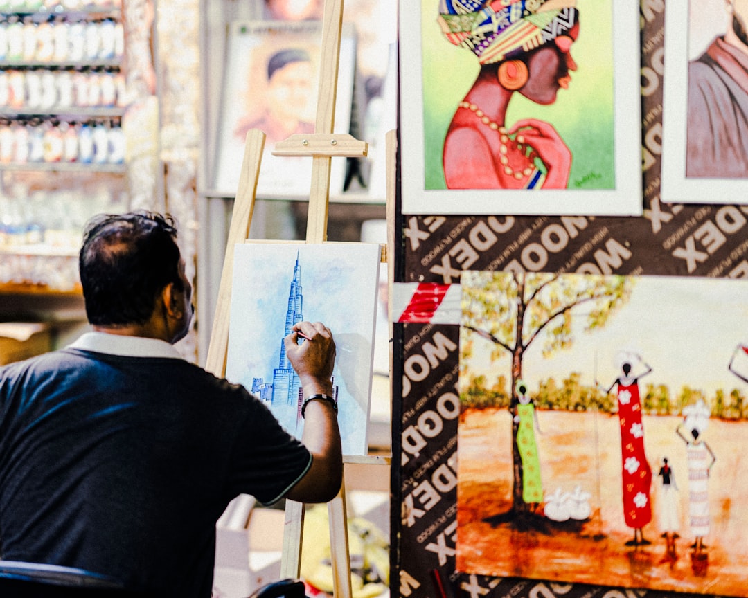 A designer works at a wooden table inside a warehouse studio that forms part of the Dubai design scene at Alserkal Avenue