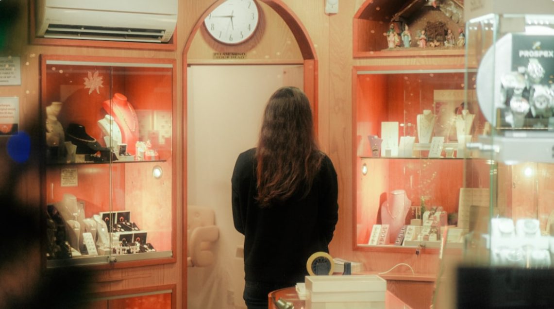 A commodity investor carefully examines gold bars inside the gold souk district, evaluating bullion for portfolio allocation