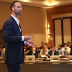 A professional man speaking in conference about how Dubai liveability draws top global talent