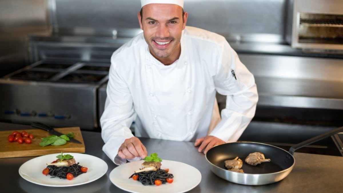 A professional chef presents a certified gluten-free dining dish at a fine restaurant in Dubai