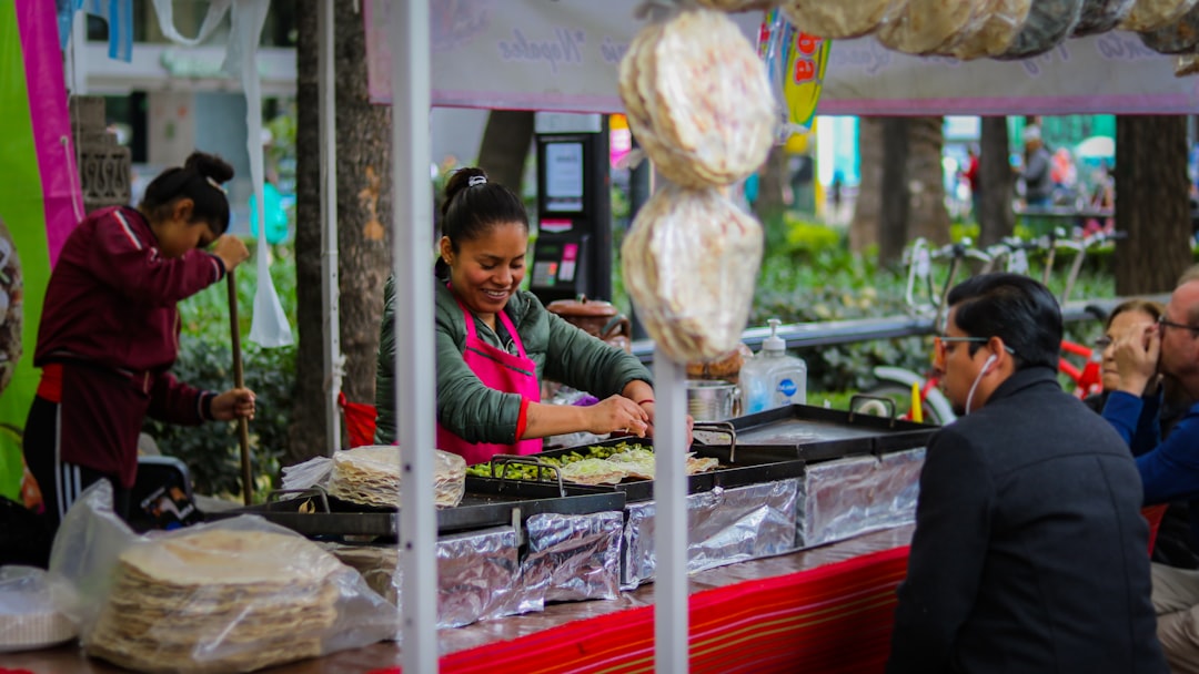 A vendor carefully wraps fresh shawarma at a busy street food stall in a Dubai corridor at night