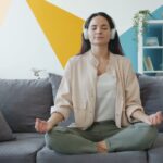 A woman practising morning meditation in her Dubai apartment, protecting her mental health during the summer.