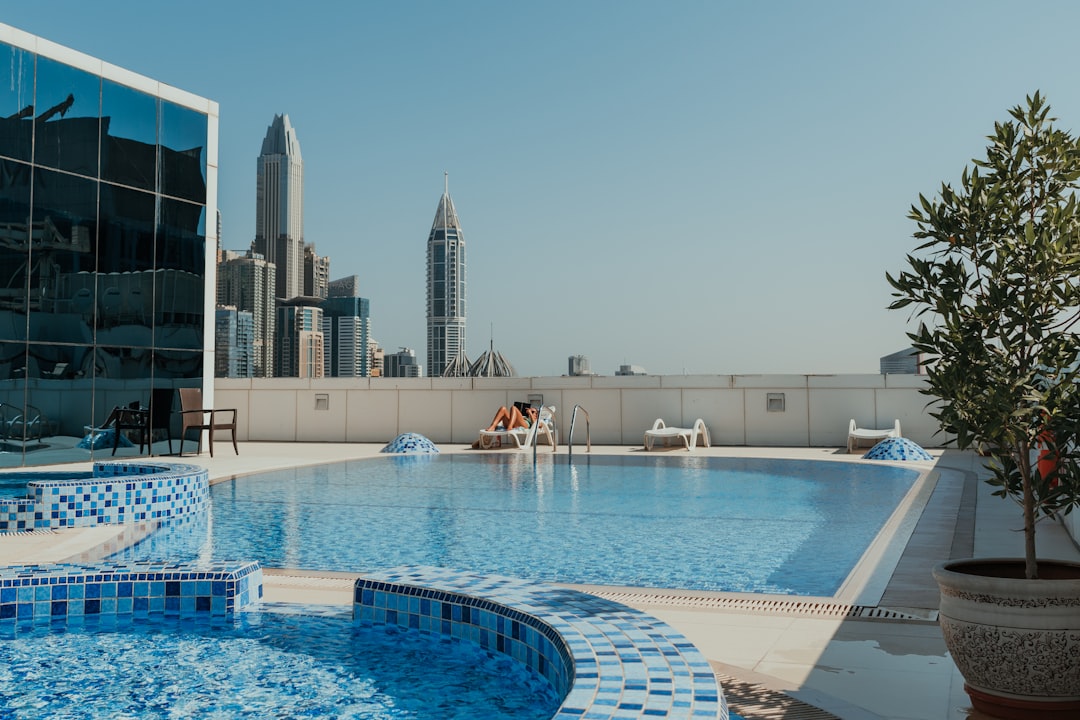 A woman relaxes at the edge of one of Dubai's most stunning luxury pools with the city skyline behind her