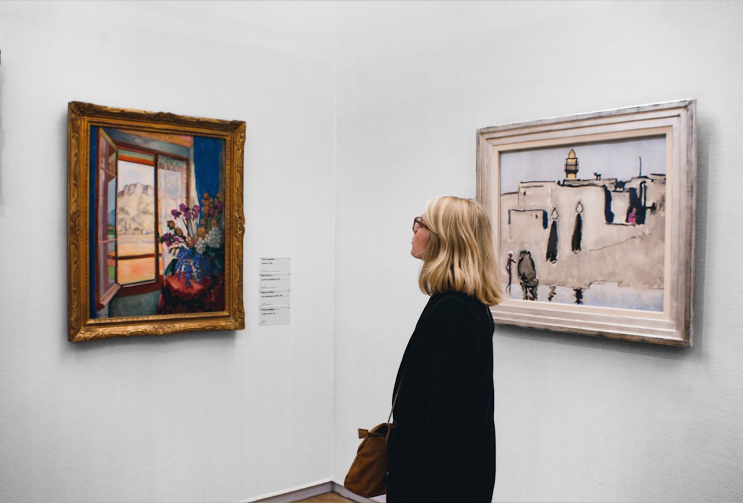 A visitor stands before a large canvas inside one of Dubai's air-conditioned art galleries during summer