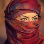 A performer delivers a monologue during an Arabic theatre production in Dubai, spotlighted on a small indoor stage.