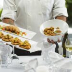 A chef presents a beautifully plated seasonal dish to diners at a Dubai restaurant launching its autumn menus