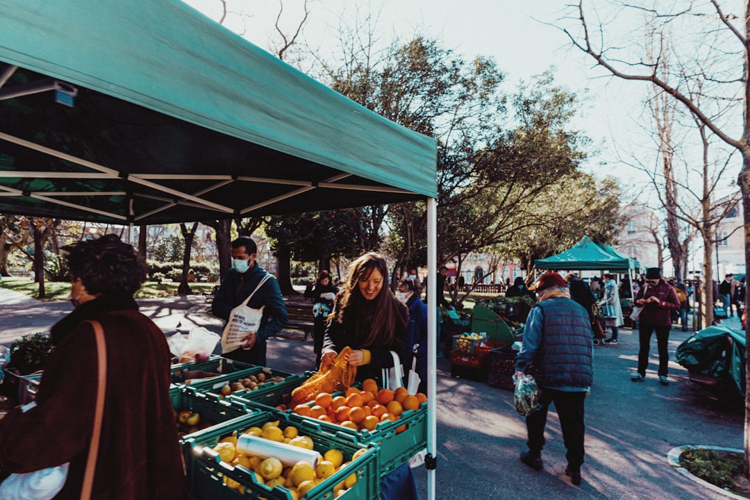 A woman selects organic vegetables at a Dubai farmers markets stall, surrounded by colourful local produce