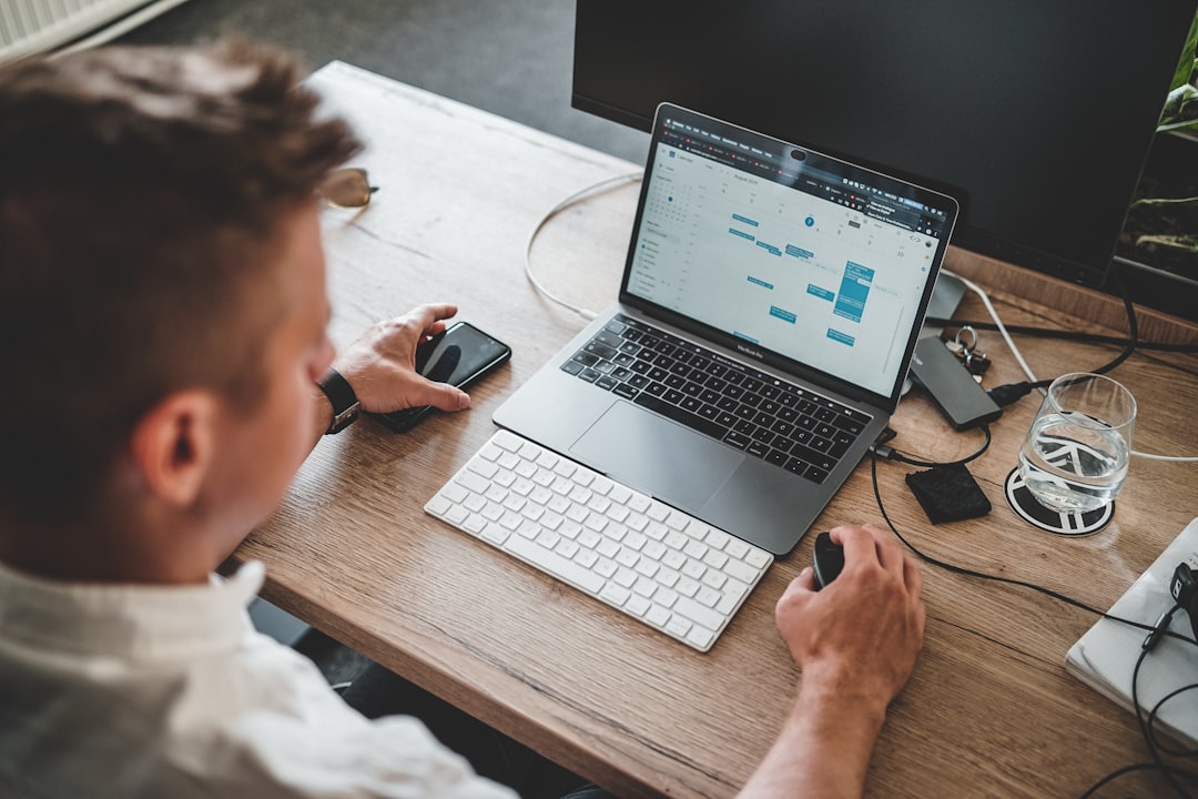 A focused professional searching for freelance clients on a laptop inside a modern Dubai coworking space