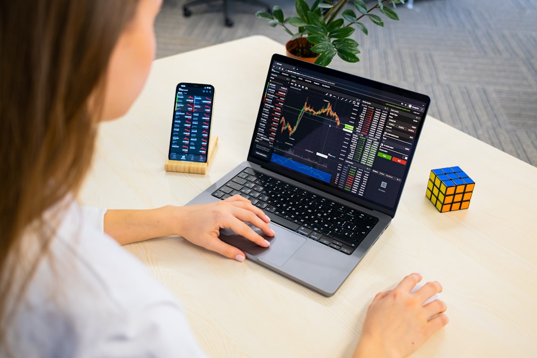 A professional woman reviewing dividend data on a laptop as part of her Dubai REITs investment research