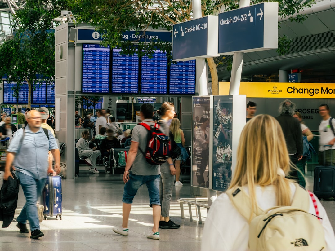 A smiling traveler checks her boarding pass at a Dubai transit hub departure gate, preparing for her connecting flight.