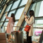 A traveler checking a boarding pass at a Dubai departure gate before flying one of the expanded Emirates routes