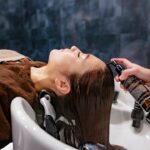 A woman applying a deep conditioning mask to repair heat damaged hair at home in Dubai