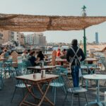 Two women enjoying coffee at an outdoor cafe as part of their social life in Dubai after summer