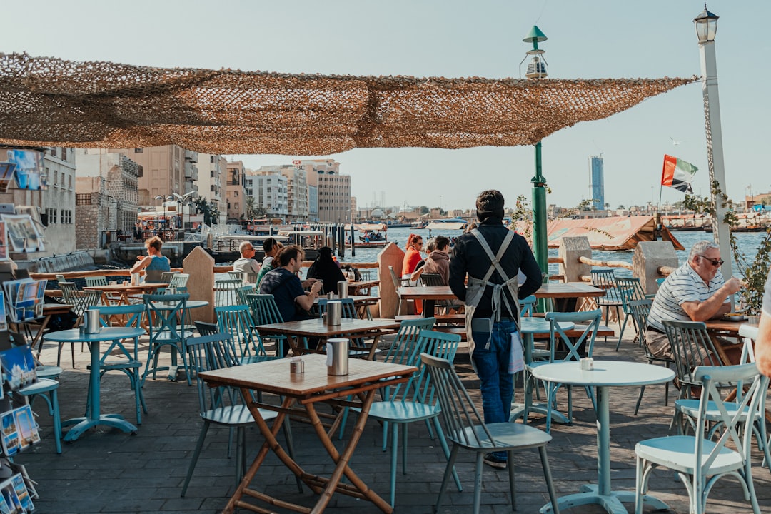 Two women enjoying coffee at an outdoor cafe as part of their social life in Dubai after summer