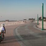 A family cycling along a beachside track in Dubai, enjoying outdoor activities together in the early morning light