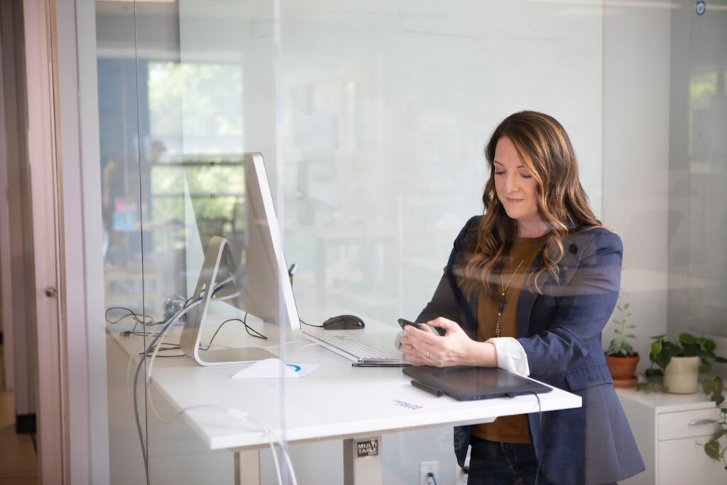 A focused entrepreneur reviews her Dubai business registration documents at a modern office desk in the UAE