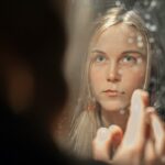 A woman applying a rich moisturizer as part of her updated skincare regimen during Dubai's seasonal humidity drop