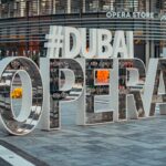 A visitor studying the Dubai cultural calendar programme outside Dubai Opera before an evening performance