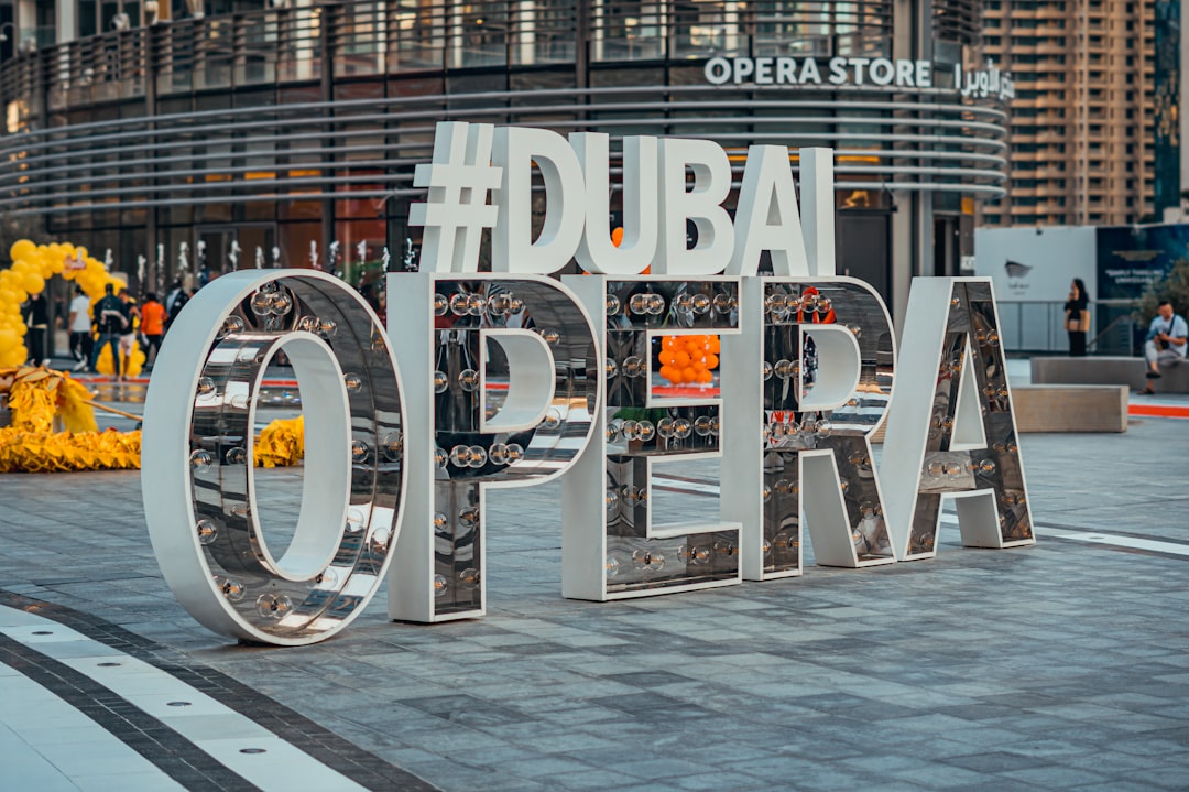 A visitor studying the Dubai cultural calendar programme outside Dubai Opera before an evening performance