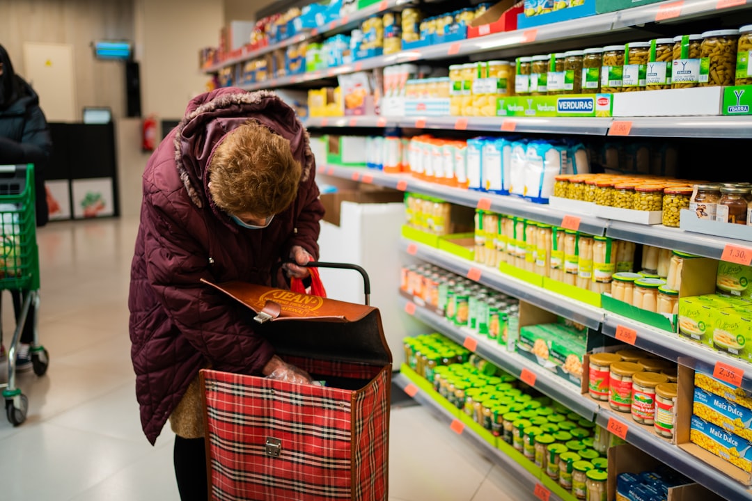 A woman choosing loose produce at a Dubai supermarket, reducing plastic use with a reusable mesh shopping bag