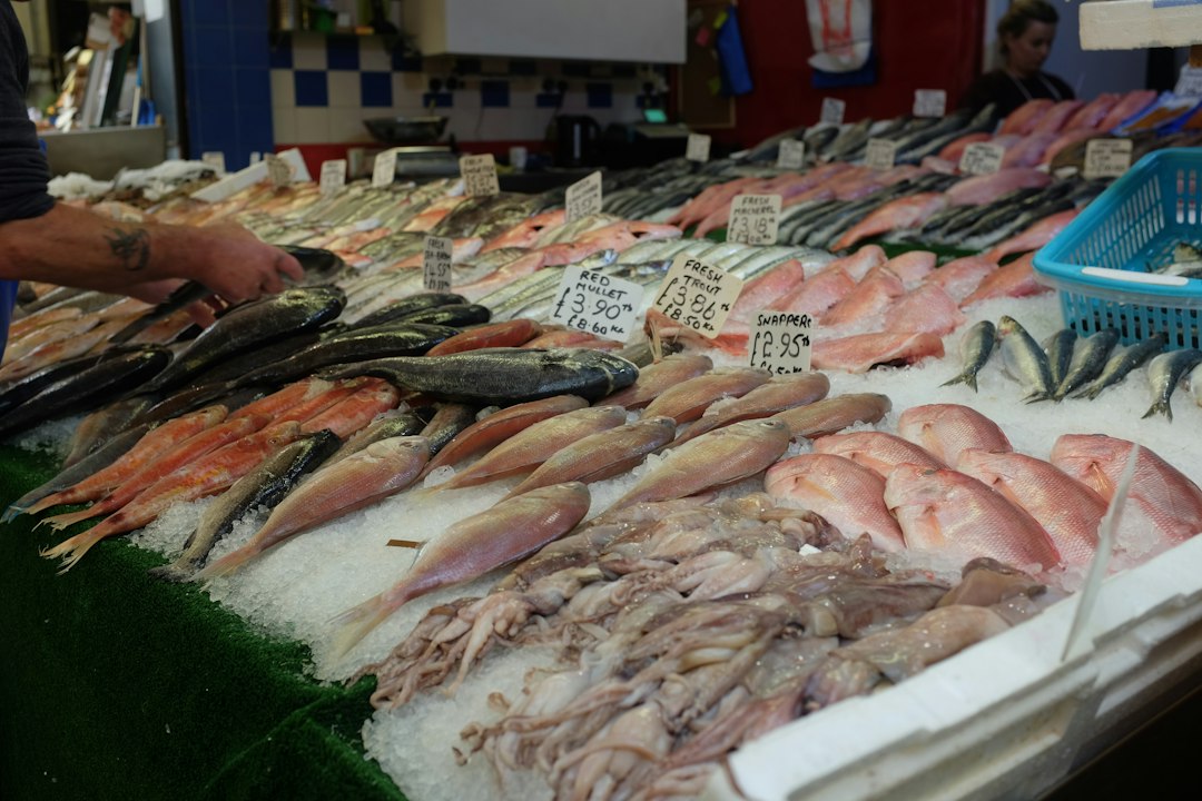 Shopper selecting hammour at a Dubai seafood market stall
